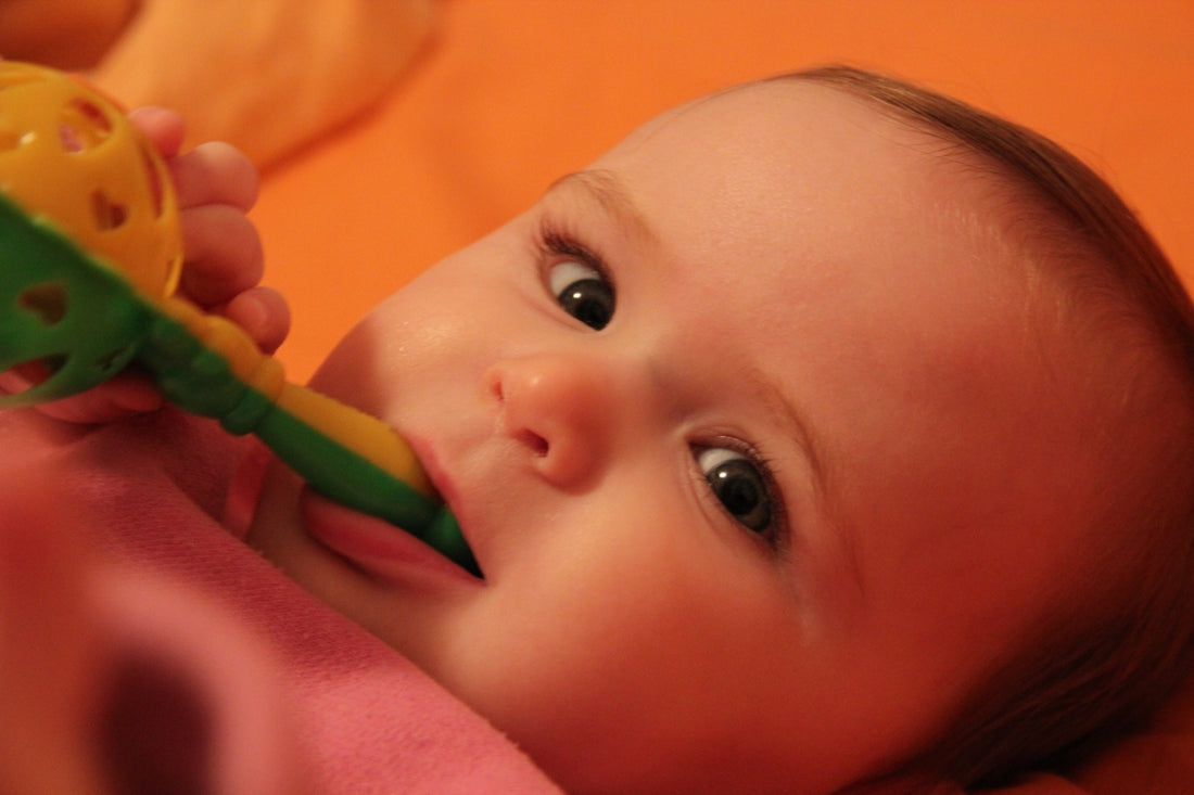 baby lying on pink textile